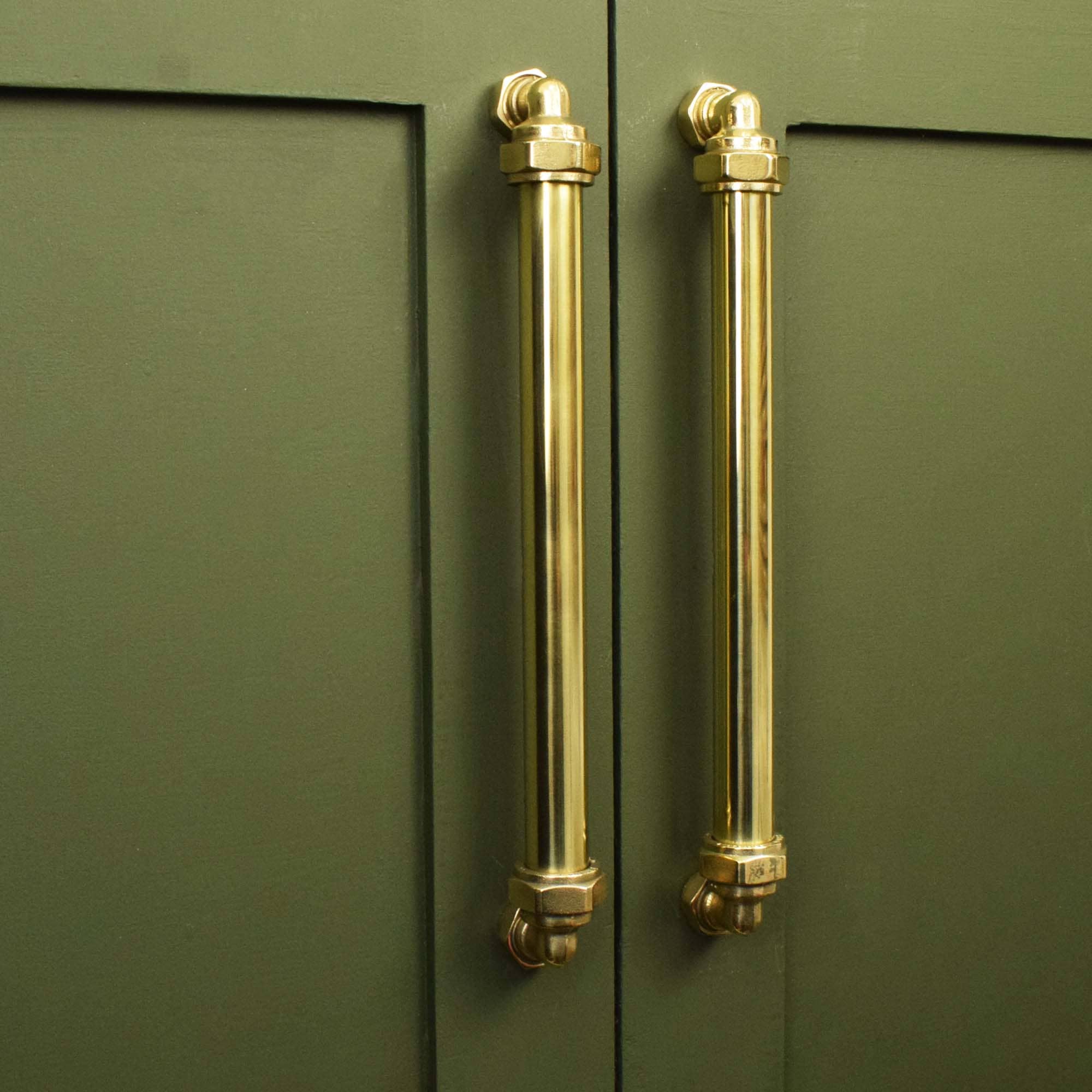 brass pillar pull on green kitchen cabinets