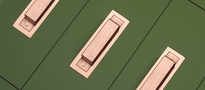 Copper handles handmade on a green drawers