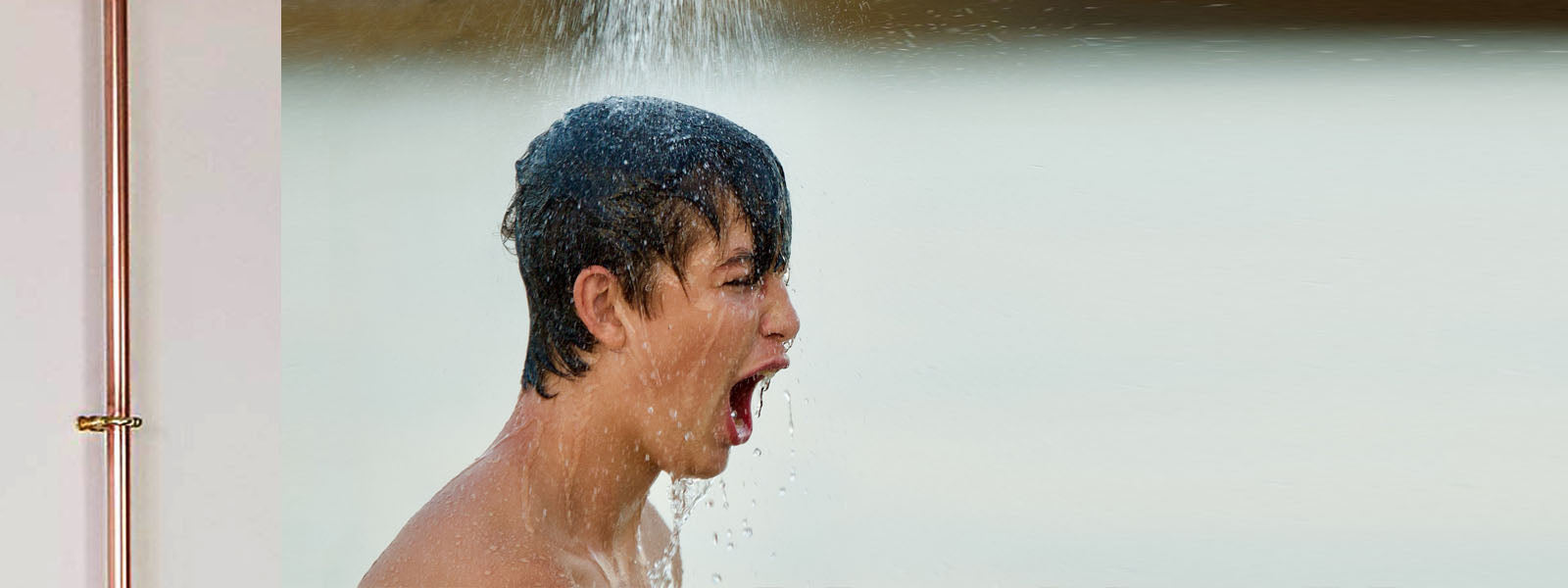 man standing in cold shower (what are the benefits of cold showers?)