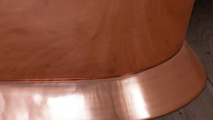 Close-up of a copper surface with a wooden base