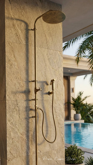 Shower system mounted on a stone wall with a pool and palm trees in the background