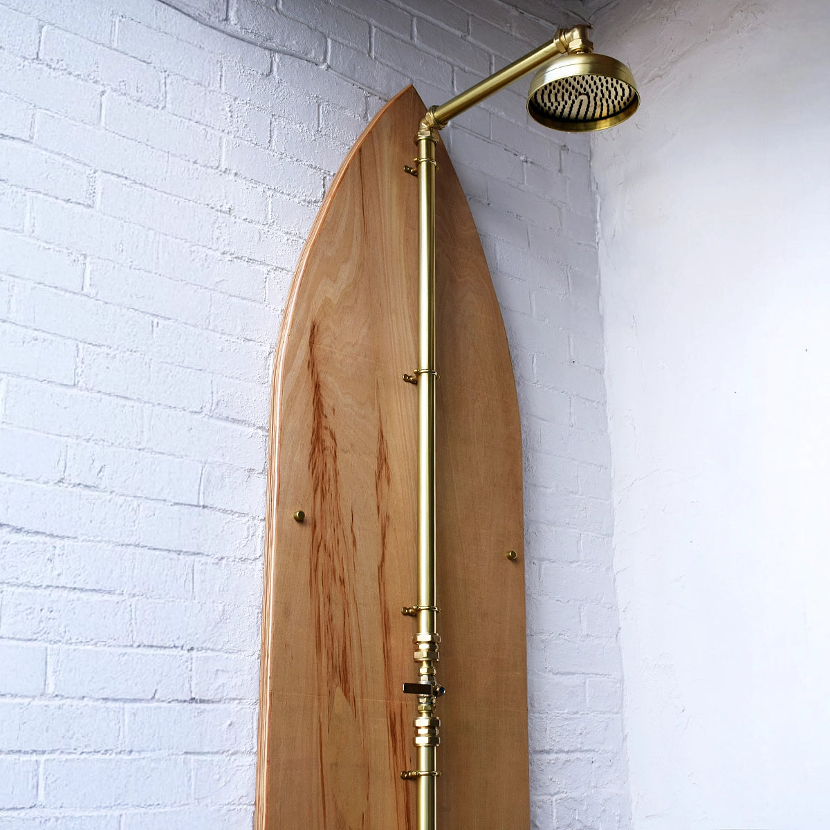 Brass shower on wood surfboard