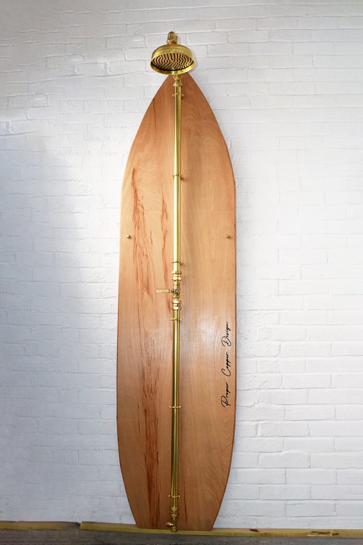 Brass shower on wood surfboard front view polished brass finish