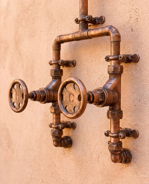 Vintage-style copper shower taps ro on a beige wallnd
