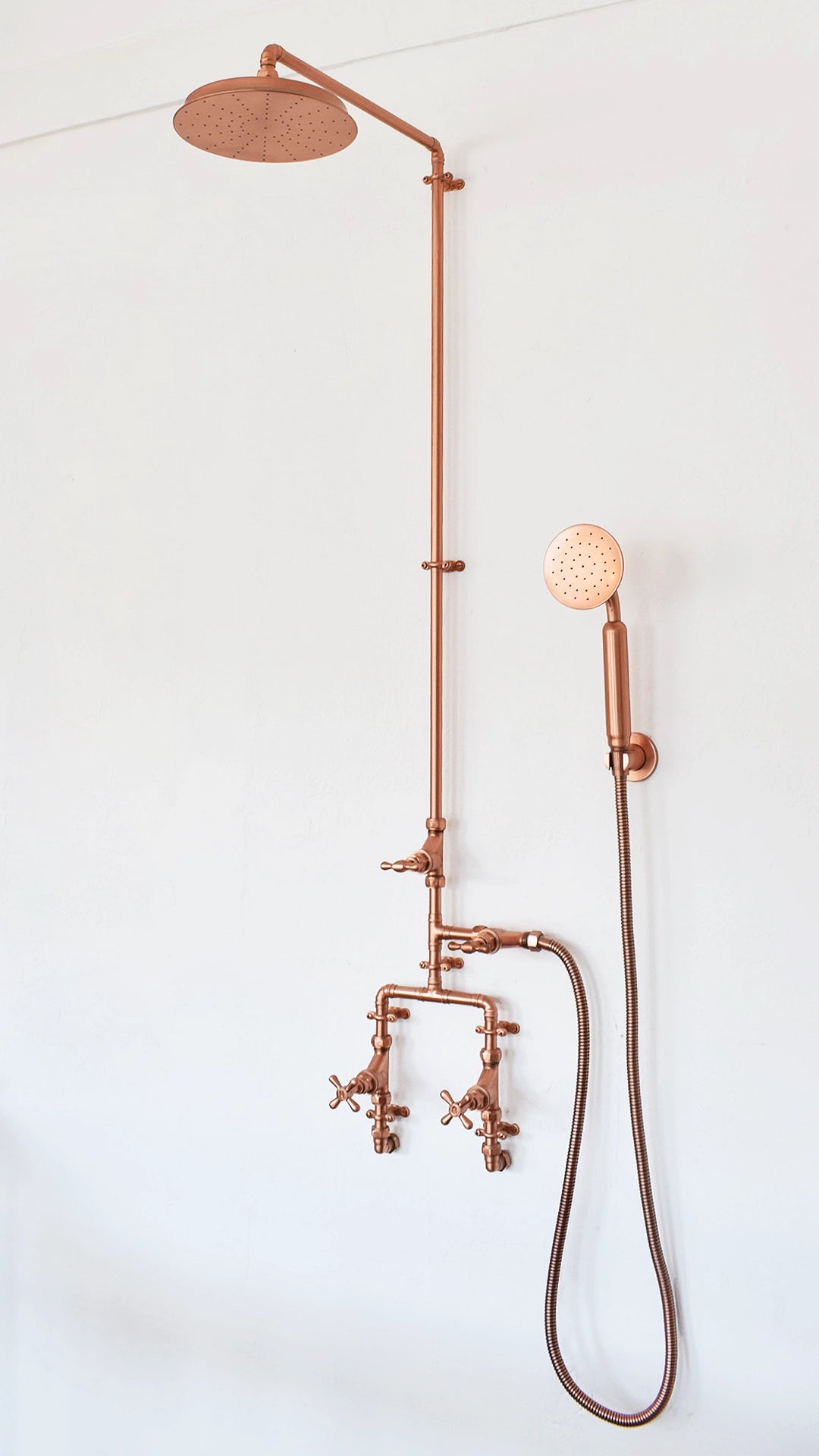 Experience the ultimate in luxury with our copper shower featuring a convenient handset for a customizable bathing experience, photographed on a white background