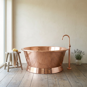 Copper bathtub with matching faucet in a bathroom setting