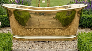 brass bathtub in a garden setting with greenery and flowers.