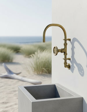 Concrete sink with brass tap on a beach setting