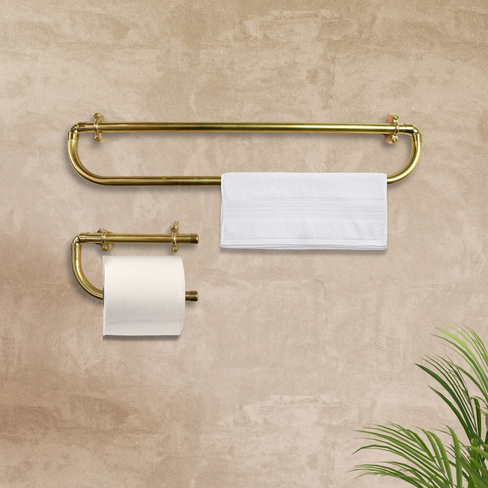 brass towel bar with toilet paper holder on a beige wall
