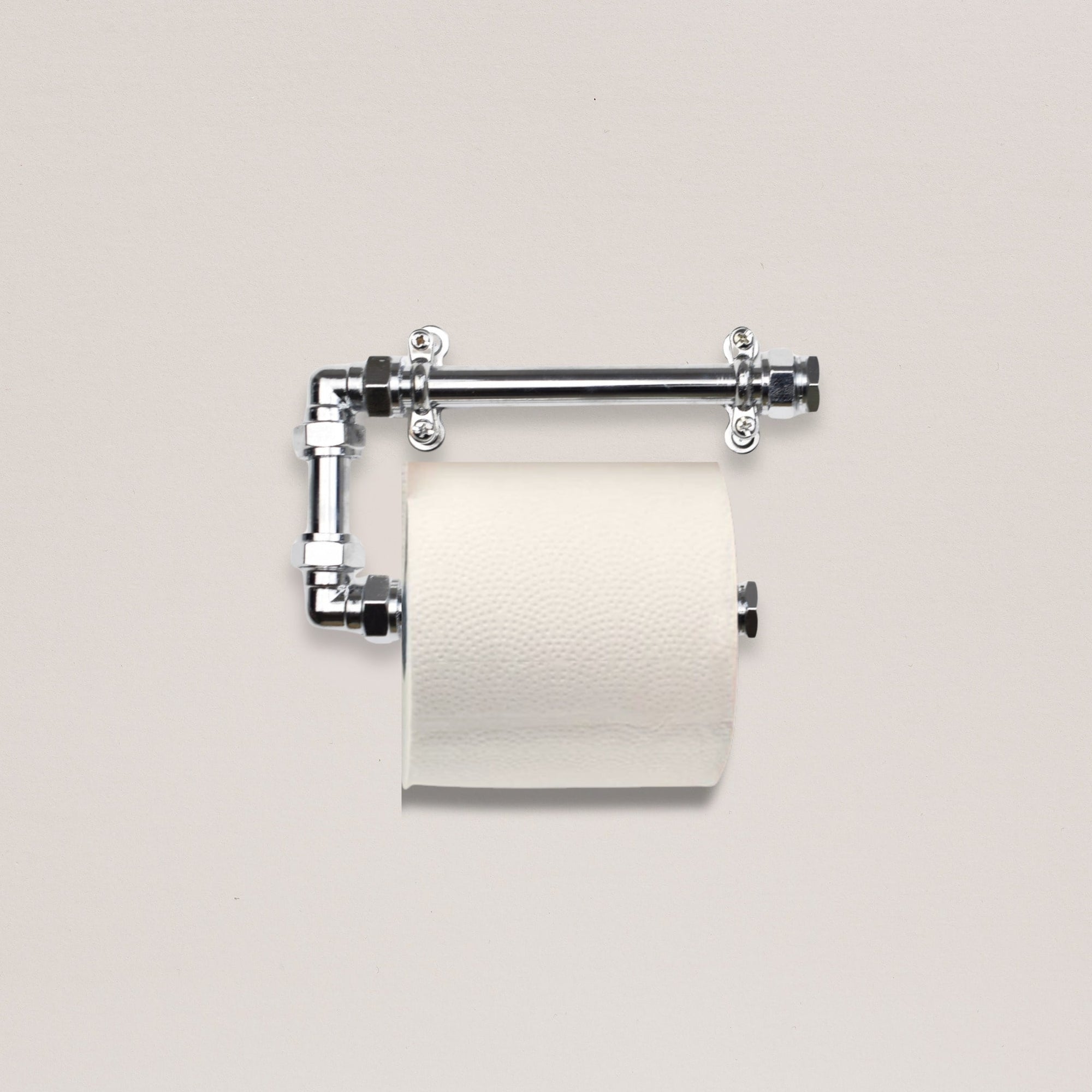 Metallic toilet paper holder with a roll of toilet paper on a light gray background