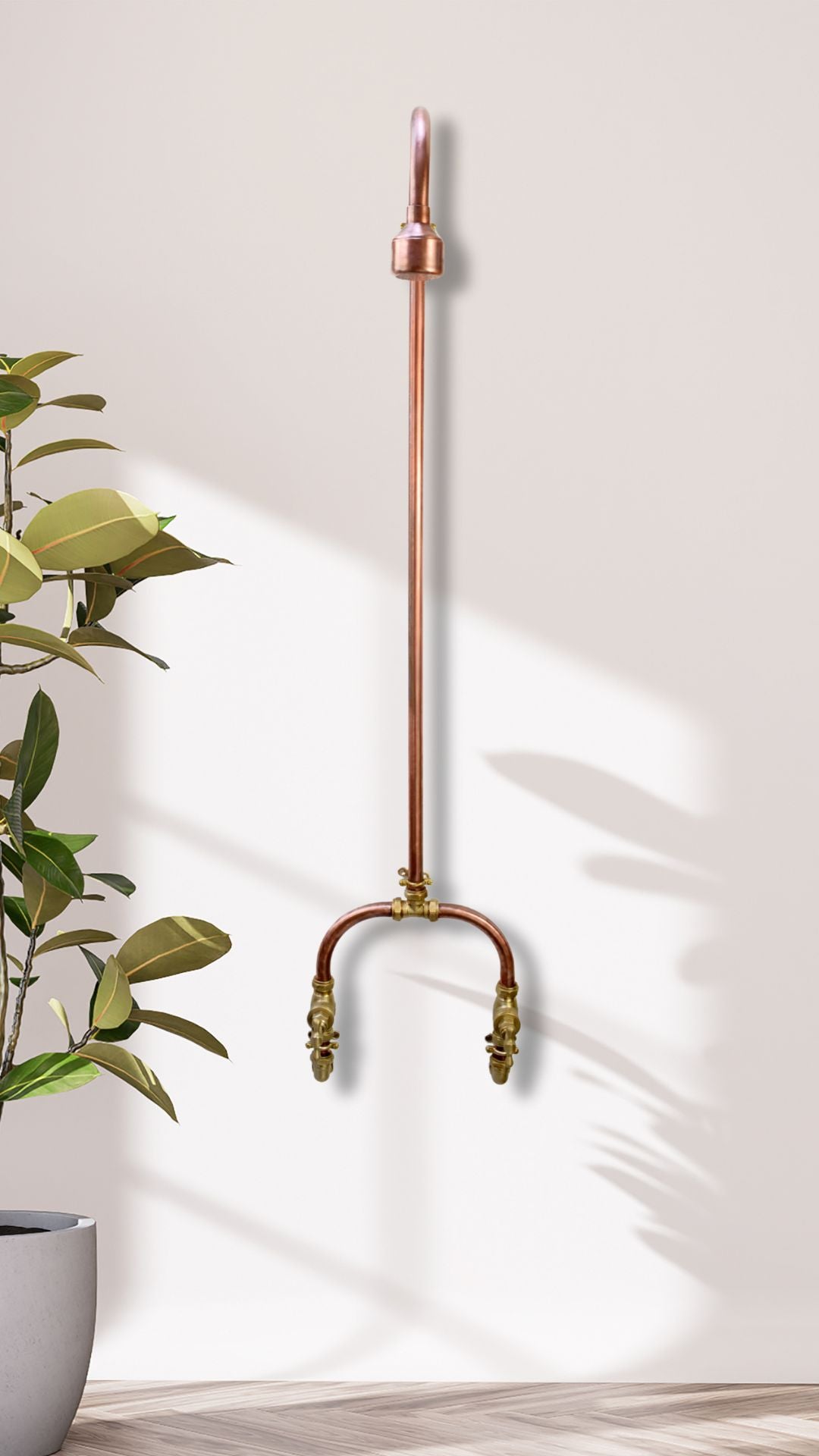 Curved Copper Shower Design, photographed next to a plant