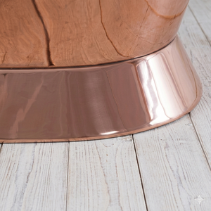 Copper-colored metal base on a wooden surface
