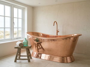 Copper bathtub in a room with a window and stool.