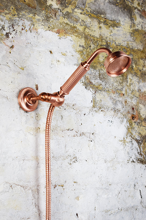 close up of angled copper handheld shower