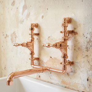 Brass faucet tap mounted on a textured wall farmhouse vintage