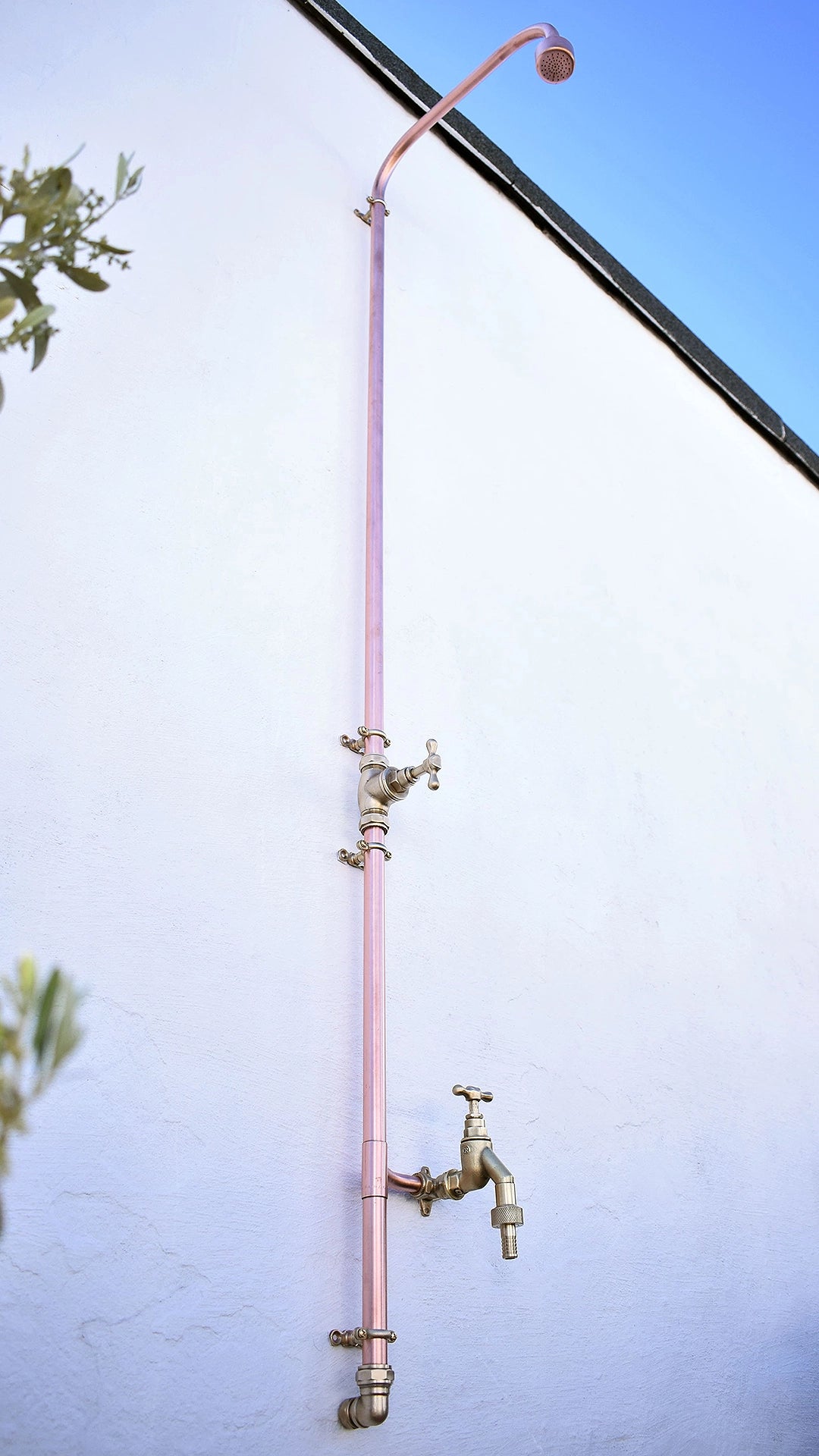 New and improved outdoor copper shower design perfect for your outdoor living space. photographed in an outdoor bathroom area of a spa resort