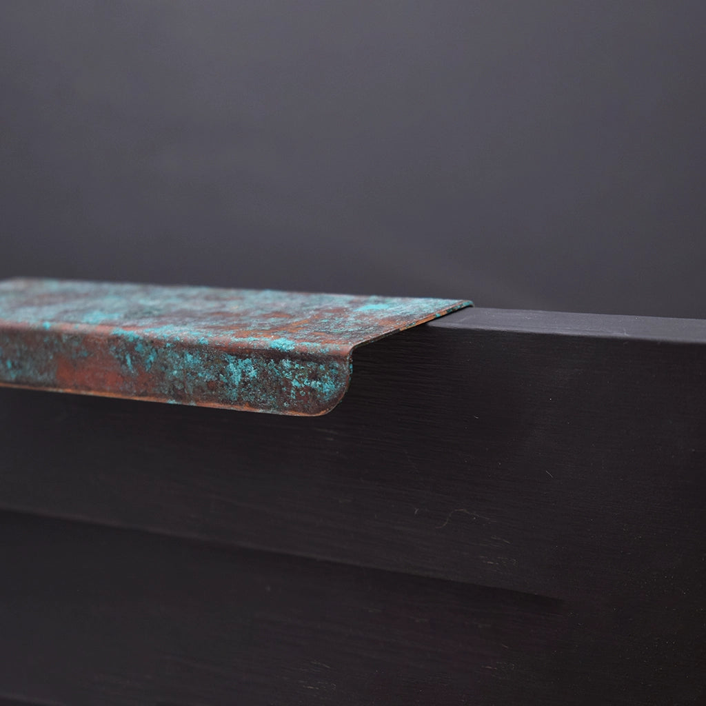 Verdigris copper folded handle on drawer close up side