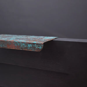 Verdigris copper folded handle on drawer close up side