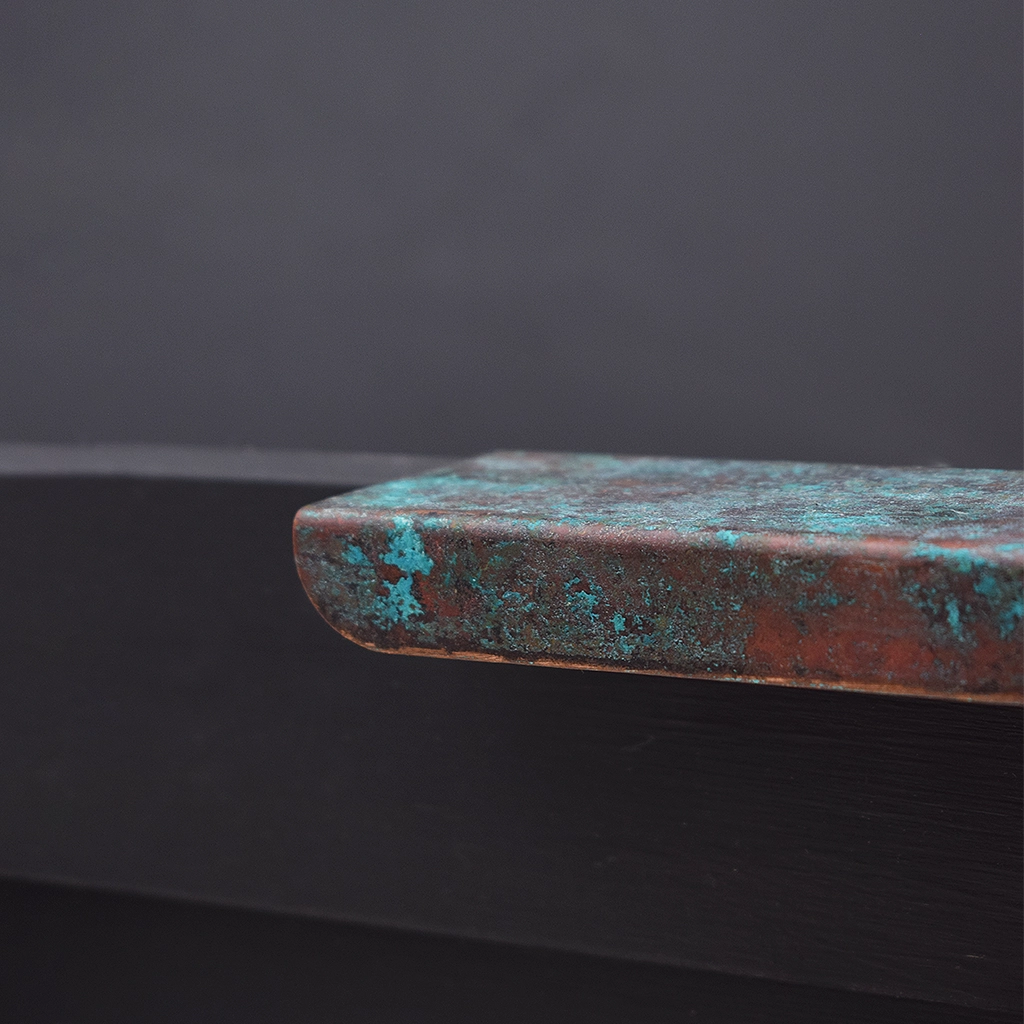 Verdigris copper folded handle on drawer close up