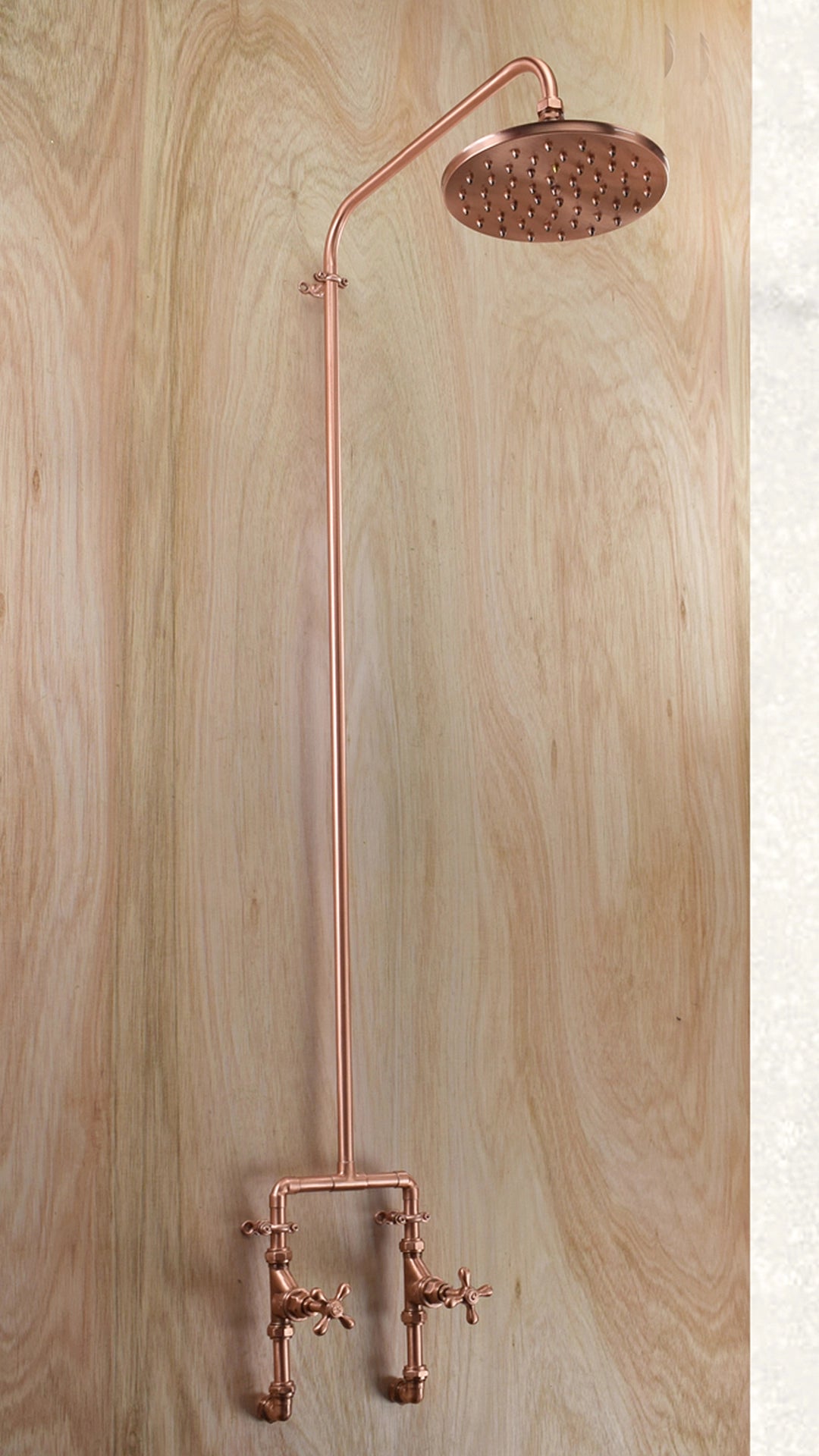 Luxor Pure Copper Shower with a flat pan copper shower head on a timber background