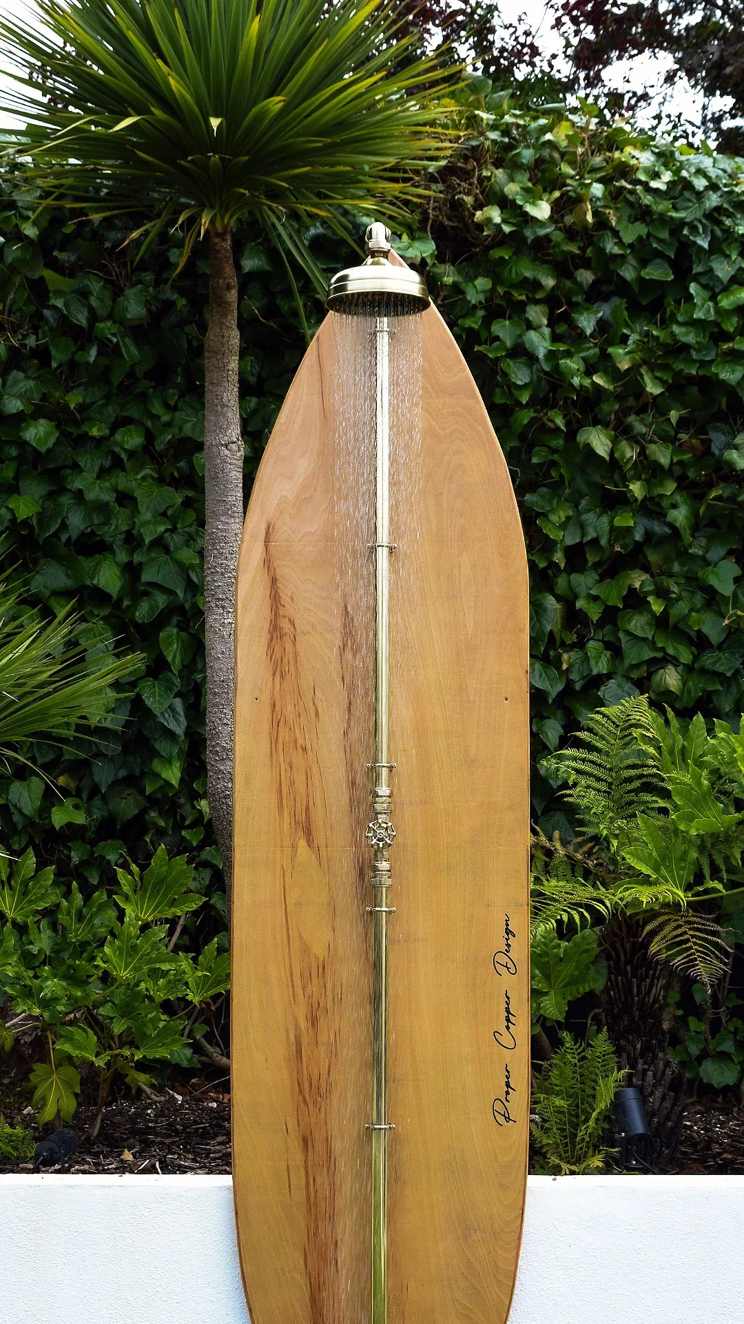 Wooden surfboard against a green foliage background