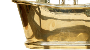 Close-up of a shiny brass bath with reflective surface