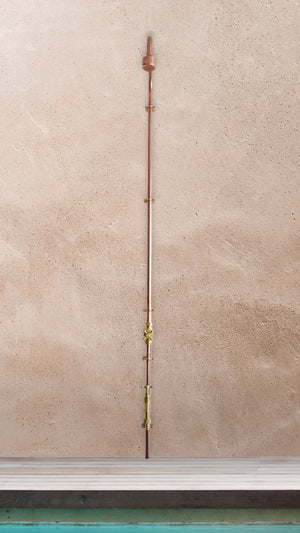 copper garden shower photographed next to a swimming pool