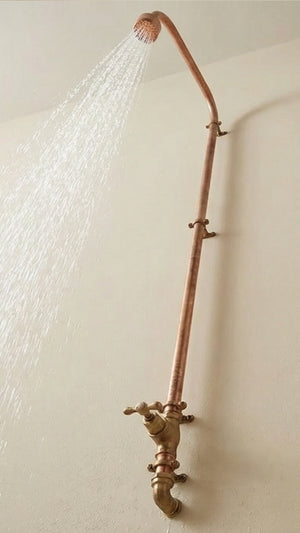Vintage-style copper shower head and hose on a white wall