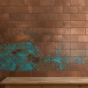 Copper tiles with turquoise patina on a wall with a wooden table in front