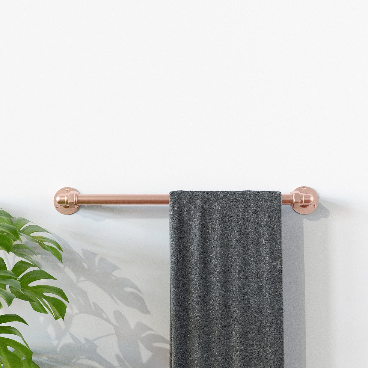 Copper towel rail with grey towel