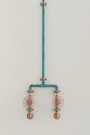 verdigris shower on white wall close up of taps