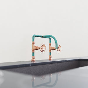 Verdigris and copper tap on kitchen surface with sink