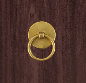 Solid brass finger pull on wooden background 