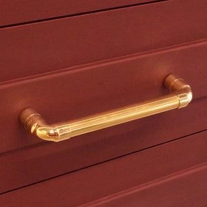 Brass pull on red drawers