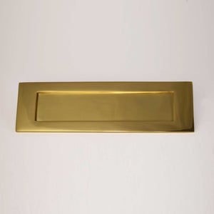 Brass letter plate on plain white background