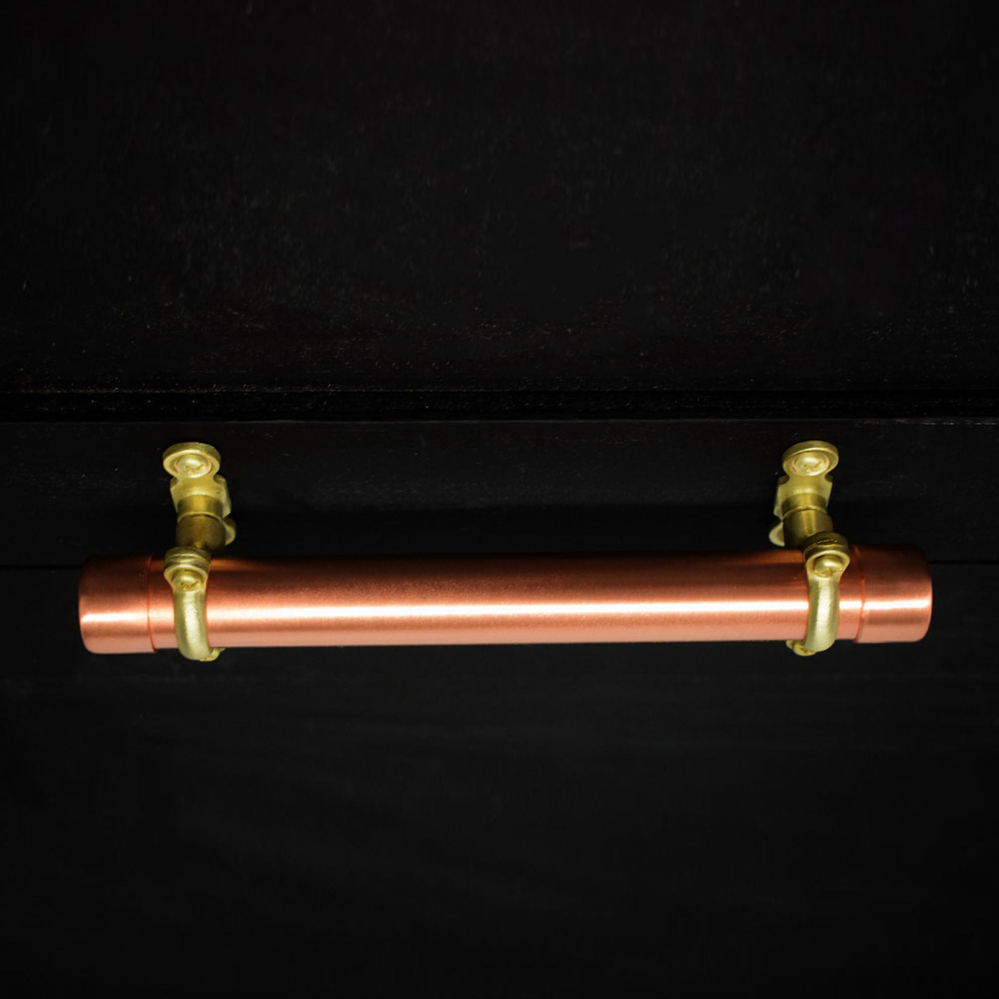brass and copper bracket pull on black