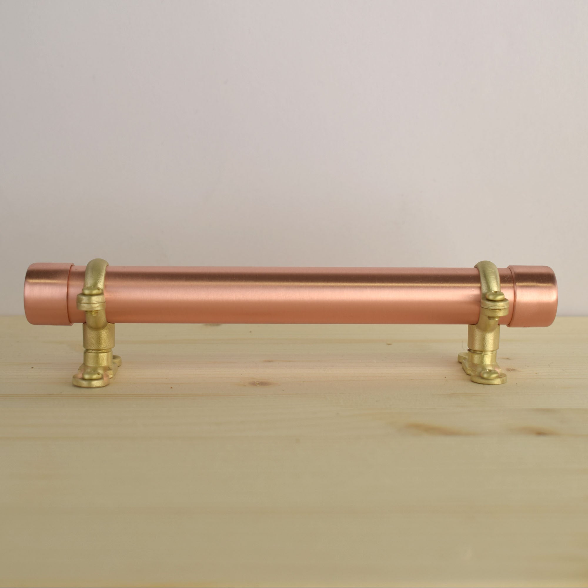 brass and copper bracket pull on wood