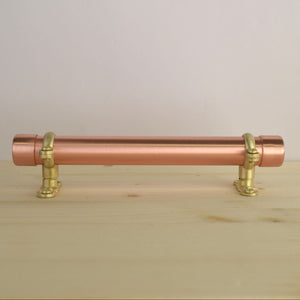 brass and copper bracket pull on wood