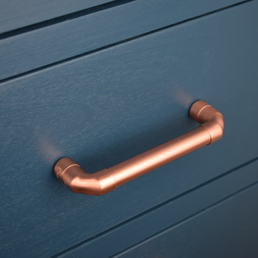 Copper Handle angled on blue cabinet