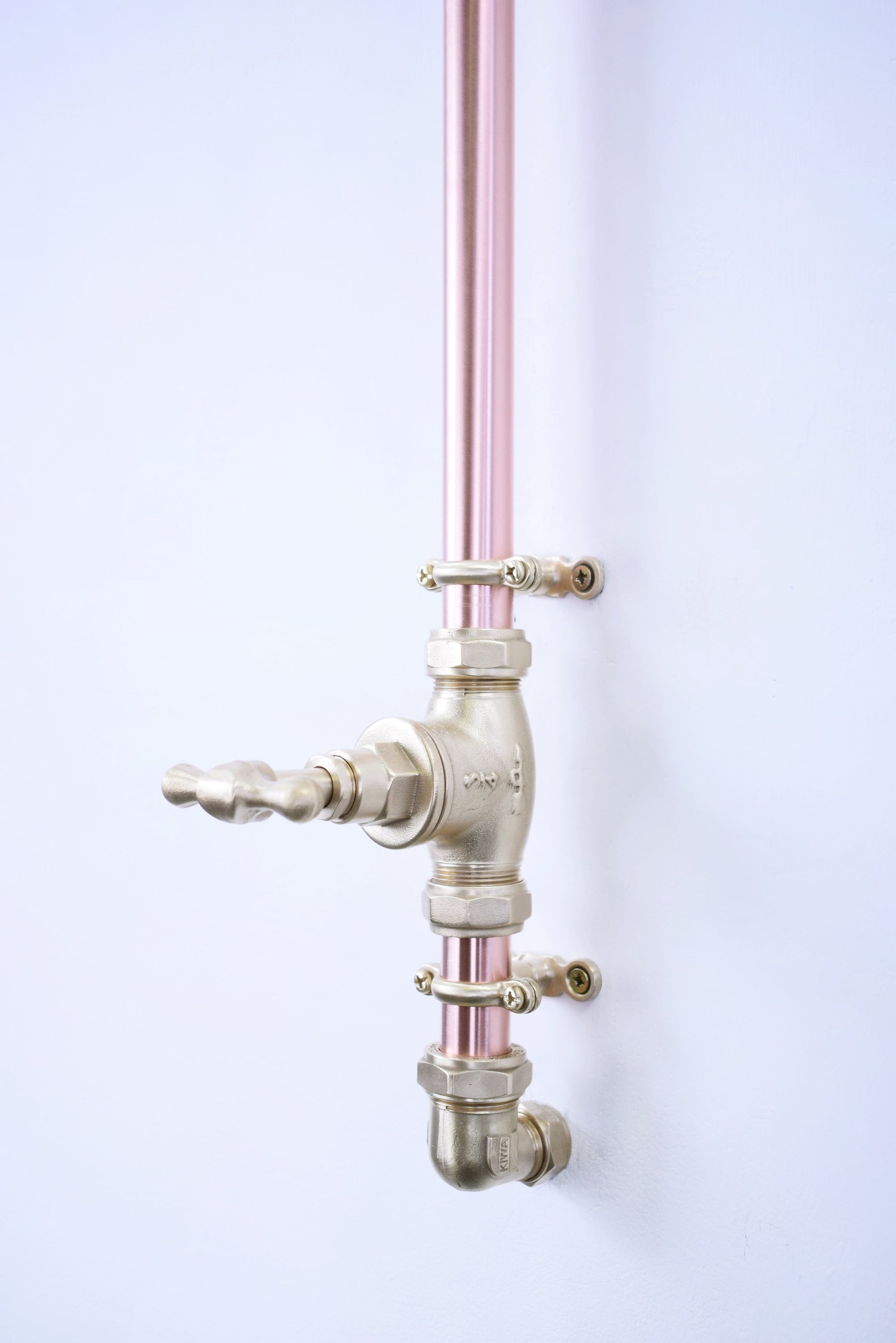 brass shower valve mounted on a therapeutic custom shower in a copper finish