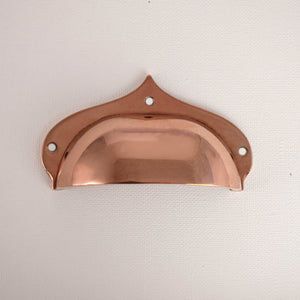 copper cup drawer pull on white background