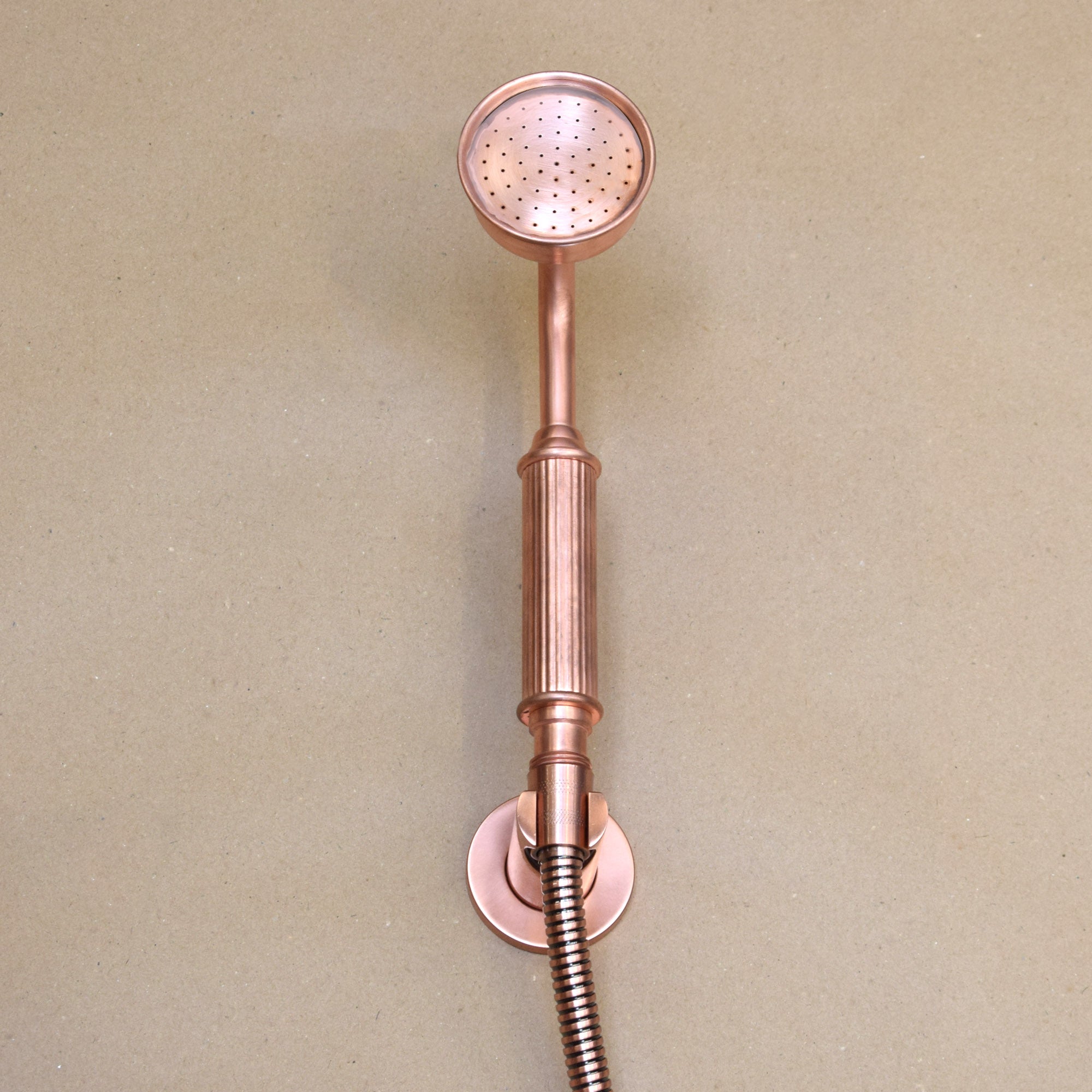 Sleek copper outdoor shower with a modern design and a helpful and stunning hand-shower attachment