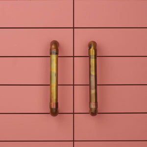 Marbled copper pull handles on red background