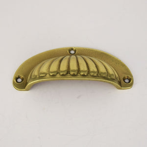 Brass Scalloped Cup Handle on plain background