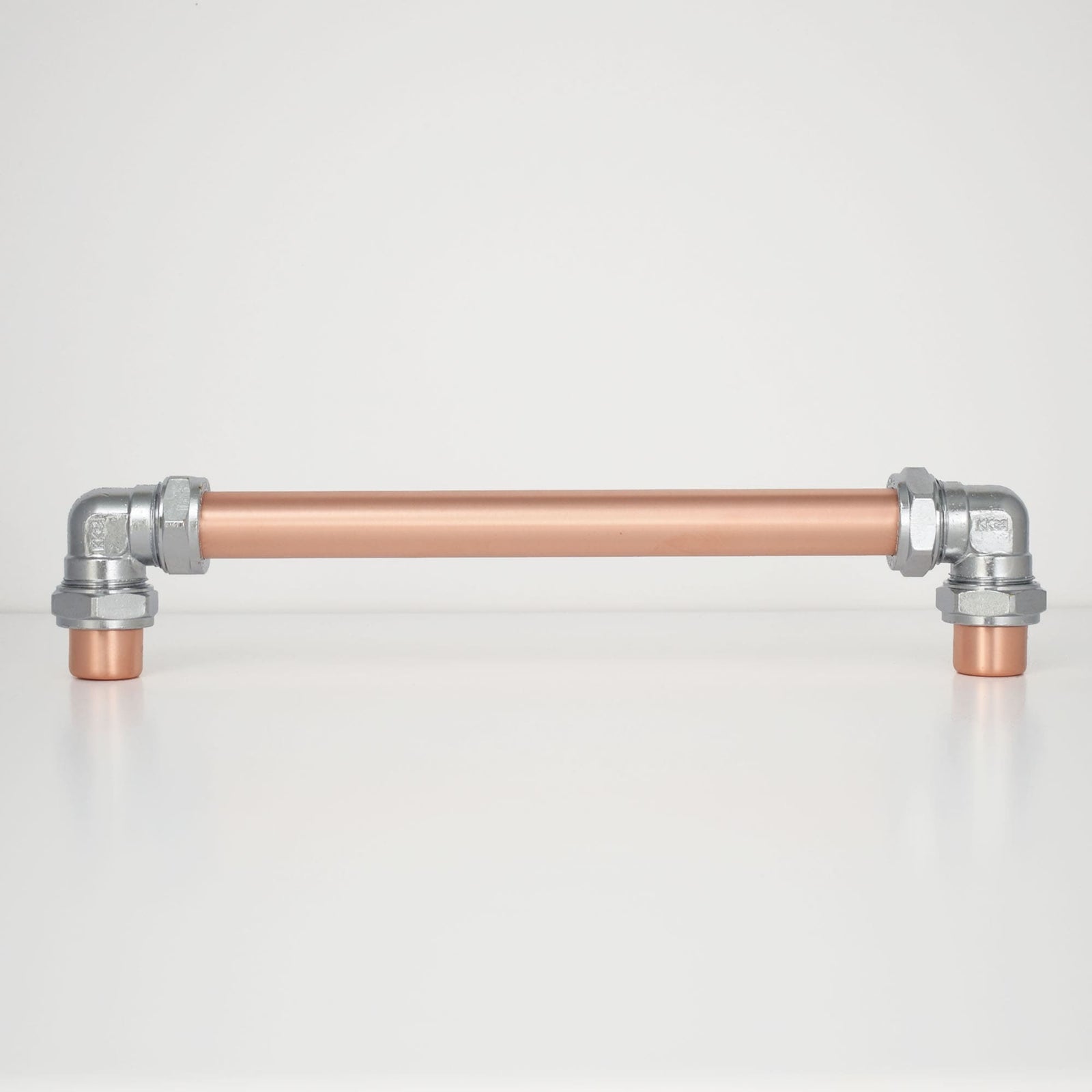 Chrome and copper barn door handle on white background