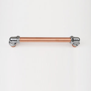 Chrome and copper barn door handle on white background top view