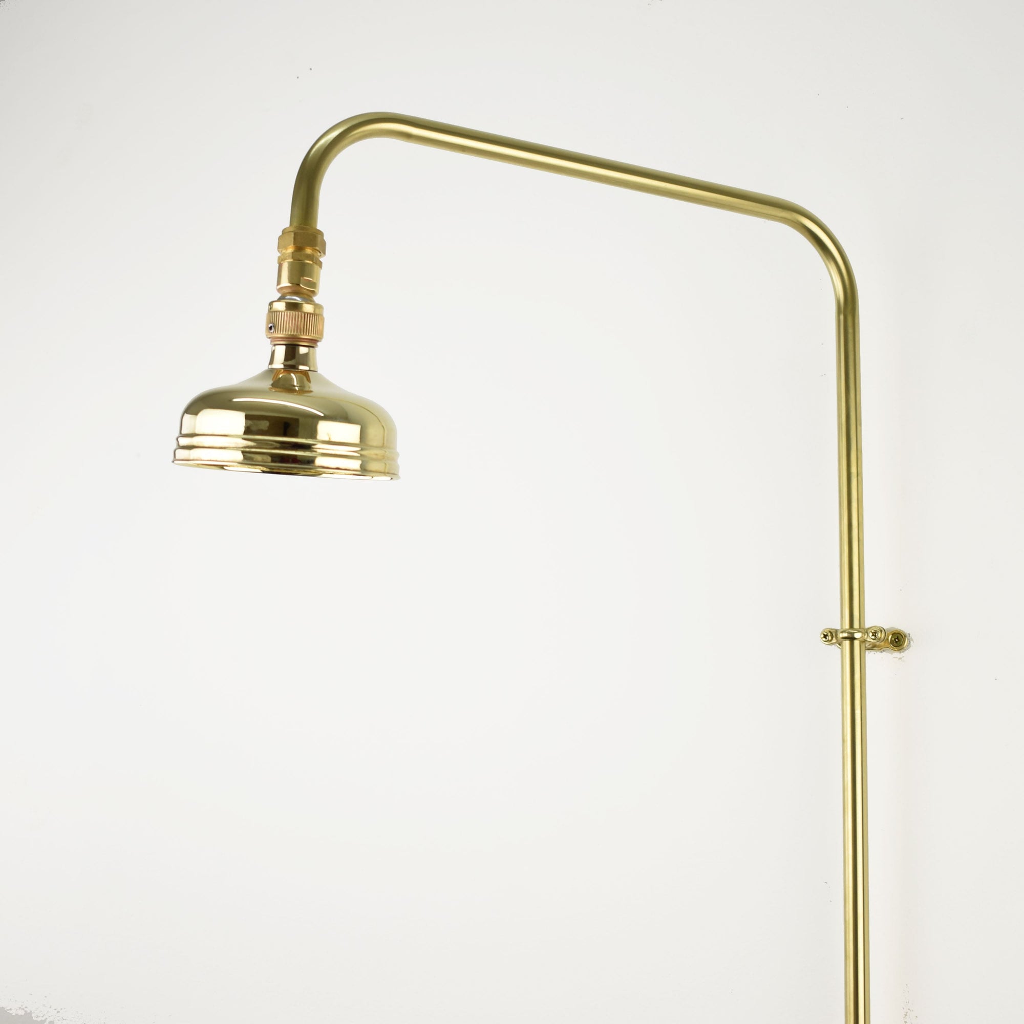 A minimalist brass shower head with a simple and elegant round design, featuring a high-pressure jet spray option
