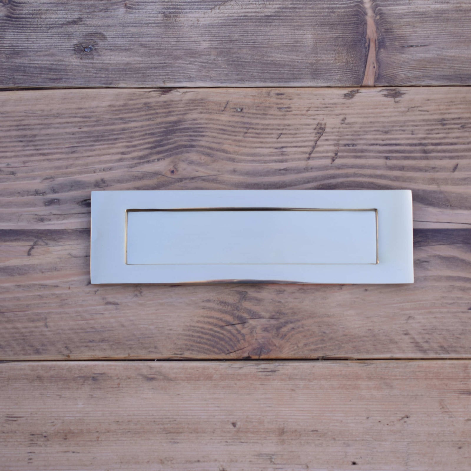 Brass letter plate on rustic wood background