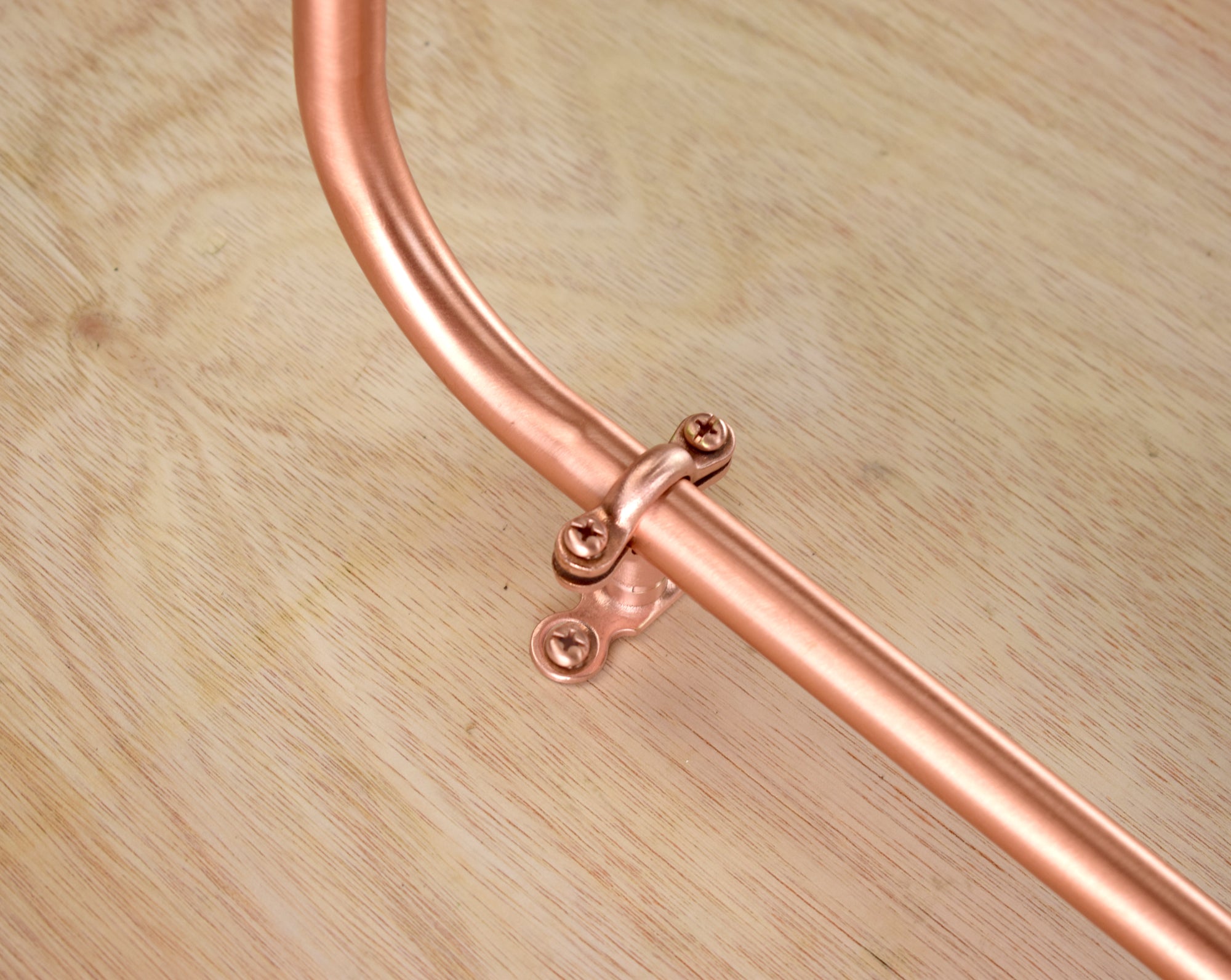 curved copper shower spout on a swimming pool or bathroom shower design