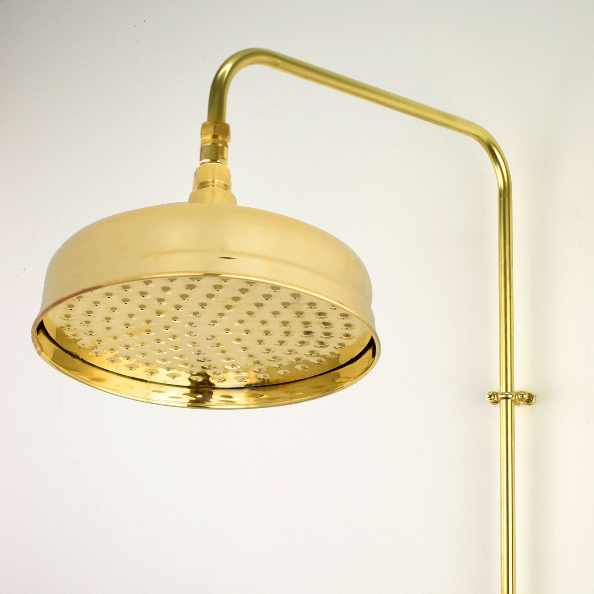 A luxurious brass shower head with a sleek and modern design, featuring a waterfall spray pattern.